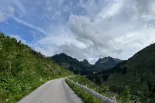 Schmale Straße mit Bergen im Hintergrund