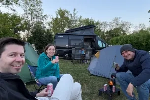 Menschen vor Zelten mit Sekt in Dosen